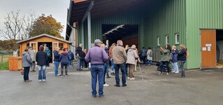 Besucher bei der Eröffnung der Bio-Milchtankstelle in Schoppendorf; im Hintergrund ist das Verkaufshäuschen zu sehen (RAG Weimarer Land-Mittelthüringen e.V.)